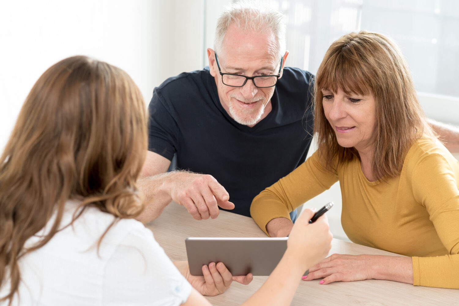 woman showing an older couple something on an ipad